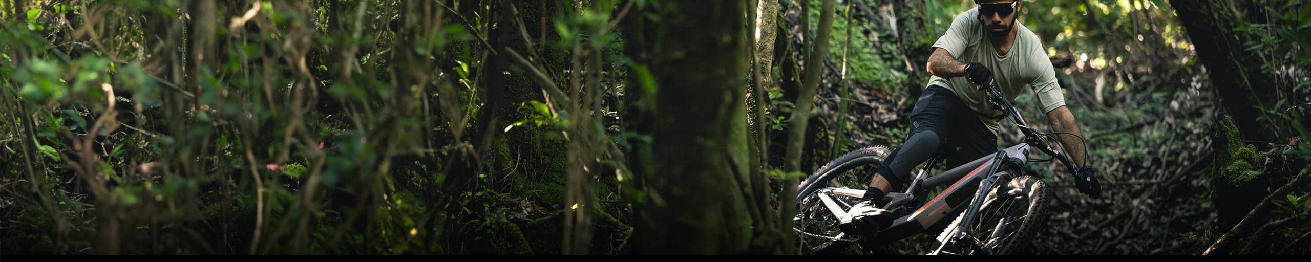 Cycliste en VTT tout-suspendu RockShox dévalant un sentier forestier technique